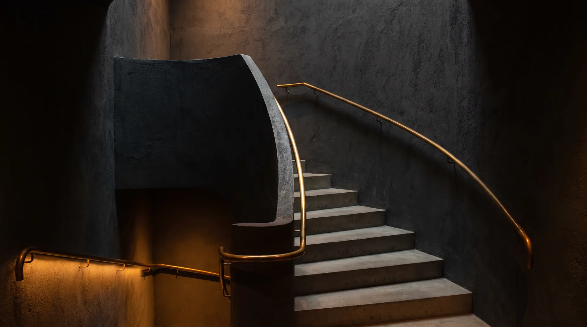 A staircase rises through warm golden light against a dark charcoal wall, symbolizing steady upward progress.